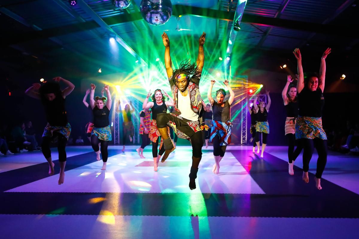 Spectacle de danse africaine sur scène, sous les projecteurs